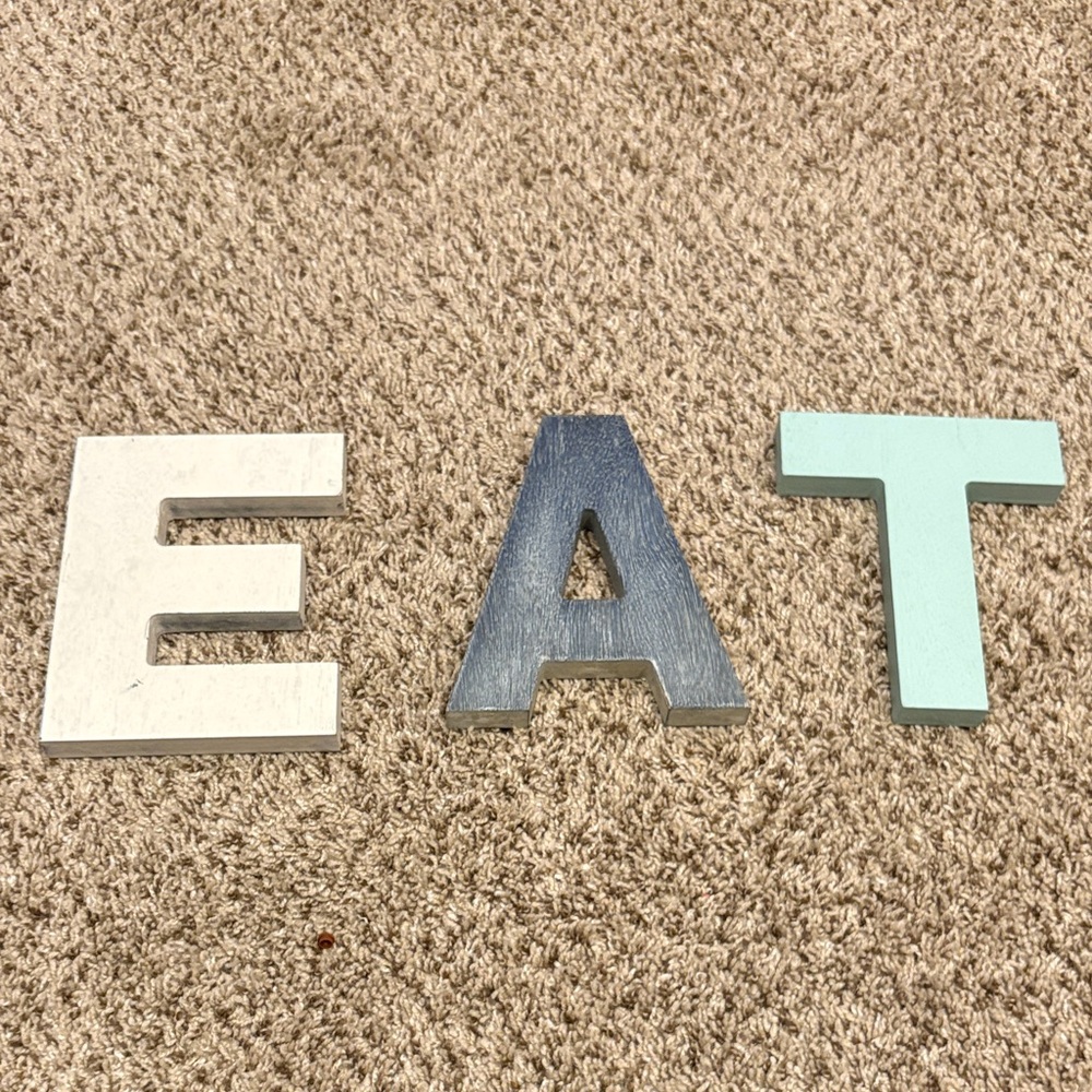 Decorative EAT Letters in white, blue/gray, and light blue